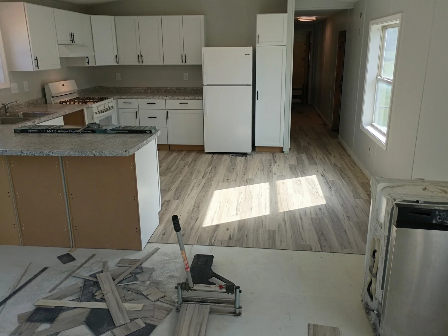The same kitchen during renovation, with replacement cabinets, countertops, and flooring